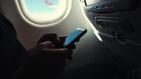 Man-using-smartphone-on-a-plane,