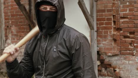 Angry-hooligan-in-black-mask-and-hood-making-kick-to-camera