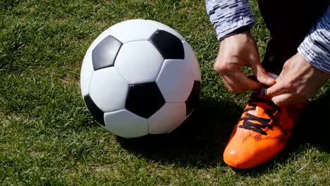 Football,-soccer-game.-Professional-footballer-buckle-his-red-shoes-before-training,-4k