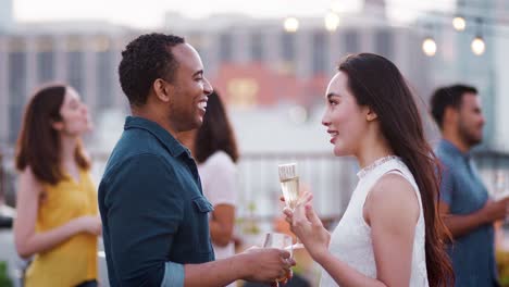 Freunde-versammelt-auf-Dachterrasse-für-Party-mit-Skyline-der-Stadt-im-Hintergrund