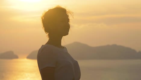 Beautiful-young-woman-wearing-fashion-colorful-dress-with-skirt-and-hat-posing-for-camera-at-sunset-on-Ponza-Island-mountain-coast-Italy.