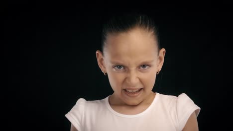 Portrait-angry-teenager-girl-clenched-fists-making-kick-with-leg-on-black-bacground