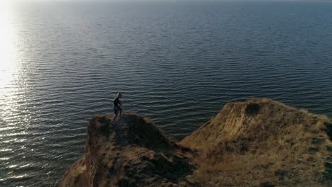 deportes-de-aire-libre,-hombres-boxeador-realiza-entrenamiento-de-boxeo-en-la-hermosa-naturaleza-cerca-mar-con-agua-brillante-cielo-luz-de-sol-brillante