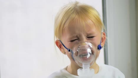 Vier-jährigen-Mädchen-in-einer-Maske-Atemgas-durch-einen-Inhalator-im-Krankenhaus-in-Zeitlupe.