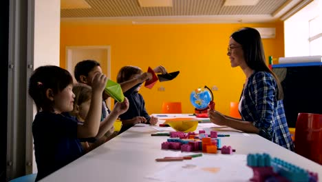 Niños-alegres-jugando-con-juguetes-de-papel-hecho-a-mano