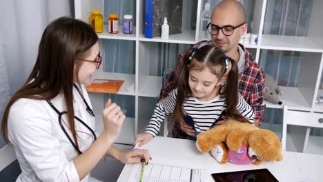 Vater-Tochter-Zeit-im-Büro-von-einem-Kinderarzt.-Weiblichen-Arzt-misst-die-Temperatur-eines-kleinen-Mädchens.