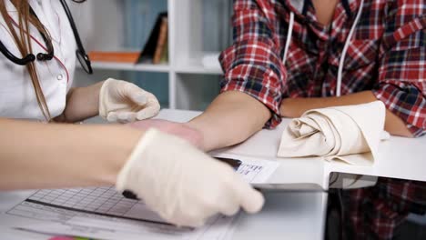 Cerca-de-hombre-paciente-mano-y-la-muñeca-con-médico-explicando-rayos-x-sobre-la-tableta.-Vista-estrecha-de-médico-senior-con-pad-electrónico-con-radiografía-de-la-muñeca-de-los-pacientes-y-la-mano