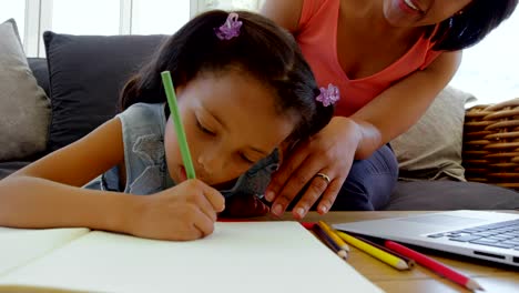 Vista-frontal-de-la-madura-negra-madre-ayudando-a-su-hija-con-la-tarea-en-una-casa-confortable-4k