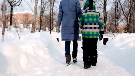 Mama-und-Sohn-zu-Fuß-im-Winterstadtpark.