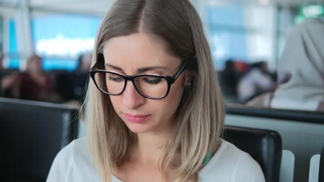 Nahaufnahme-von-jungen-Mädchen-mit-Brille-arbeiten-auf-Laptop-am-Flughafen.