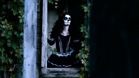 A-young-woman-with-spooky-skeleton-Halloween-make-up-looking-out-the-window.-4K