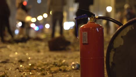 Feuerlöscher-in-den-zerstörten-Straßen-einer-Stadt-nach-einem-heftigen-Zusammenstoß-mit-der-Polizei