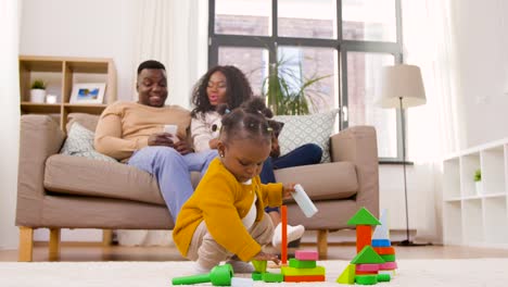 afrikanische-Baby-Mädchen-spielen-mit-Spielzeug-Blöcke-zu-Hause