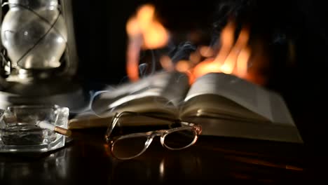 Libro-abierto-sobre-la-mesa-delante-de-la-chimenea-de-leña