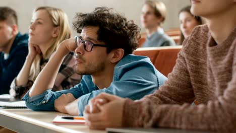 Aburrido-grupo-de-alumnos-escuchando-una-conferencia-en-la-Universidad.-Hombre-joven-cansado,-agotado-y-con-exceso-de-trabajo.