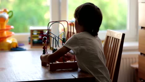 Niño-preescolar,-jugando-con-los-juguetes-en-una-habitación-soleada,-desarrollo-infantil