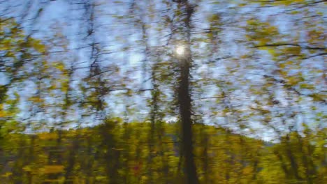 Otoño-de-conducción---conducción-en-una-carretera-de-montaña-en-un-hermoso-día-de-otoño.-Punto-de-vista-de-la-ventana-lateral-de-un-coche,-cámara-en-mano