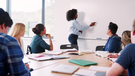 Tutor-de-la-mujer-secundaria-en-clase-de-matemáticas-de-enseñanza-pizarra