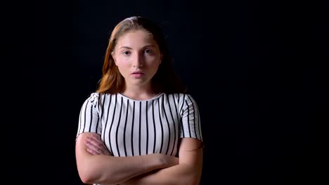 Young-beautiful-woman-with-ginger-hair-crossing-hands-and-looking-with-serious-expression-at-camera,-concerned