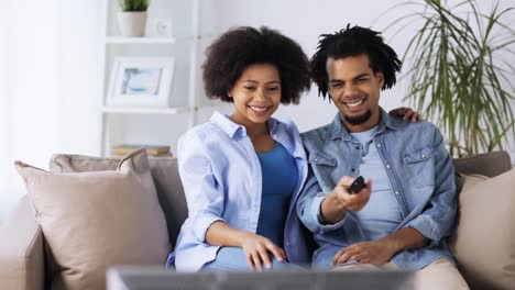 happy-smiling-couple-watching-tv-at-home