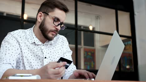 Man-using-online-banking-with-laptop-and-card