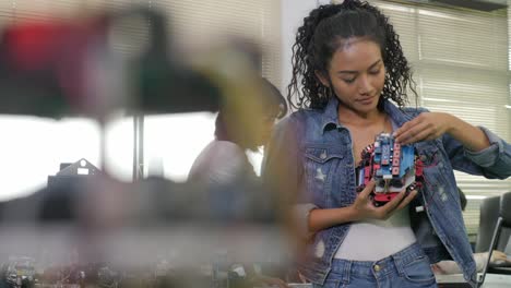 Equipo-de-ingeniero-electrónico-trabajando-juntos,-colaborando-en-un-proyecto-para-construir-el-robot.-Personas-con-el-concepto-de-tecnología-o-innovación.