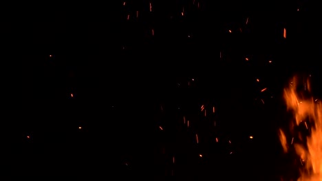 high-speed-shot-of-fire-flames-and-glowing-ash-particles-on-black-background