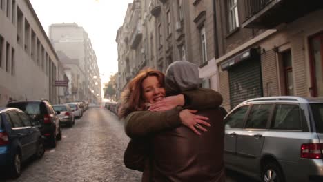 Cute-young-couple-running-towards-each-other-on-the-street.