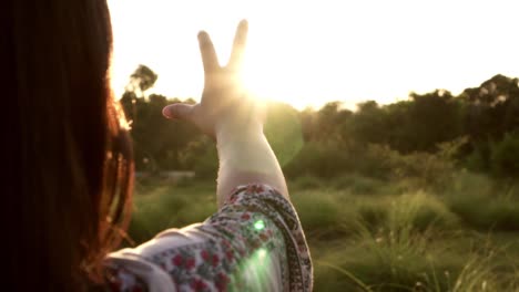 Sonnenlicht-durch-weibliche-Hände,-während-ihr-Blick-auf-Sonne