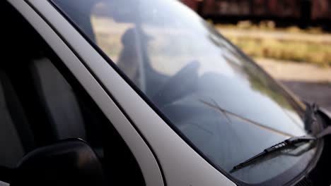 Staging-scene-of-a-scary-young-woman-sitting-in-a-van,-get-out-of-car-and-see-a-horror-picture-of-two-zombies-coming-directly-to-her.-Day-time.-Handhelded-footage