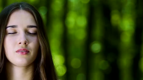 Woman-meditating-with-closed-eyes-in-forest,-camera-pan,-place-for-ad-text-slow