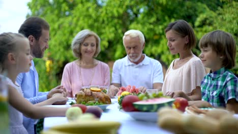 Gran-familia-orar-juntos-diciendo-gracia-antes-de-la-comida,-religión-y-espiritualidad