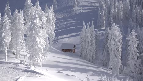 Herrliche-Winterlandschaft-der-Berge-und-Tannen-bedeckt-mit-Schnee,-isoliert-wenig-Holzhaus,-Skifahrer-auf-der-Piste,-Zeitraffer-von-Lichtern-und-Schatten