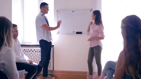 group-psychotherapy,-girl-standing-in-front-of-an-audience-of-people-on-board-with-word---motivations-draws-chart-with-an-arrow-upwards