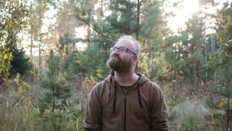 Portrait-of-a-young-man-with-a-beard-who-raised-his-hands-up-to-the-sky.-The-concept-of-joy-and-happiness