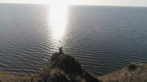 hacer-boxeo-entrenamiento-de-deportista-en-la-naturaleza-en-la-montaña-cerca-del-agua-brillante-cielo-luz-de-sol-brillante