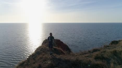 Outdoor-Sportarten,-klettert-Athlet-Hang-in-der-Nähe-von-brillant-Wasser-auf-schöne-Natur-am-Berg-gegen-Himmel-im-sonnigen-Licht