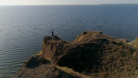 hombre-luchador-hacer-entrenamiento-de-boxeo-en-la-hermosa-naturaleza-en-la-montaña-cerca-de-río-con-agua-brillante-contra-el-cielo-en-rayos-de-sol