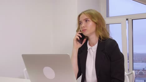 Angry-business-woman-scolding-while-mobile-conversation-in-business-office