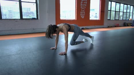 Joven-sano-hermoso-fit-mujer-haciendo-push-ups-de-entrenamiento-en-el-gimnasio.-Concepto-de-deporte,-fitness,-salud.-Cámara-lenta.