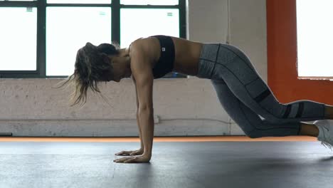 Mujer-joven-sana-hermoso-deportiva-sexy-empuja-hacia-arriba-el-ejercicio-intensivo-de-entrenamiento-en-el-gimnasio-de-entrenamiento.-Cámara-lenta.