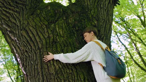 Girl-hugs-a-big-tree-in-the-forest.