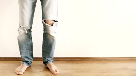 Funny-male-showing-Dance.-Legs-in-torn-jeans-against-the-white-wall.