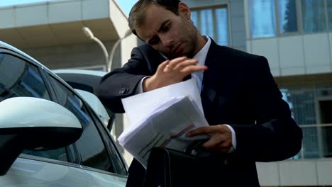 Business-person-talking-on-phone-near-car,-solving-financial-issues-of-company