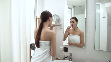 Salud-dental.-Mujer-cepillado-de-los-dientes-en-el-baño