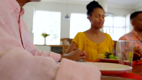 Familia-de-generación-negro-multi-orar-juntos-en-mesa-de-comedor-en-hogar-confortable-4k