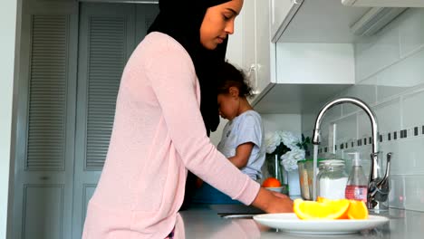 Young-mother-washing-dishes-in-kitchen-at-home-4k