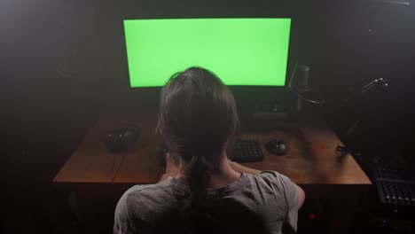 Creative-man-working-in-front-of-the-computer.-Before-him-is-a-green-screen.-4K-Slow-Mo