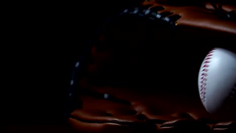 Werfen-Sie-einen-Baseball-mit-einem-Baseballhandschuh,-in-ein-dunkles-Licht-gelegt