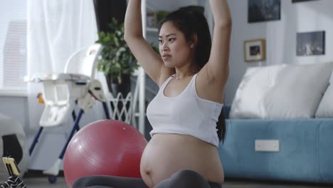 Pregnant-woman-watching-tutorial-video-during-workout